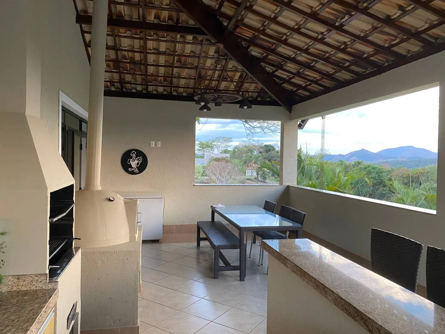 Área gourmet coberta com mesa e vista para as montanhas