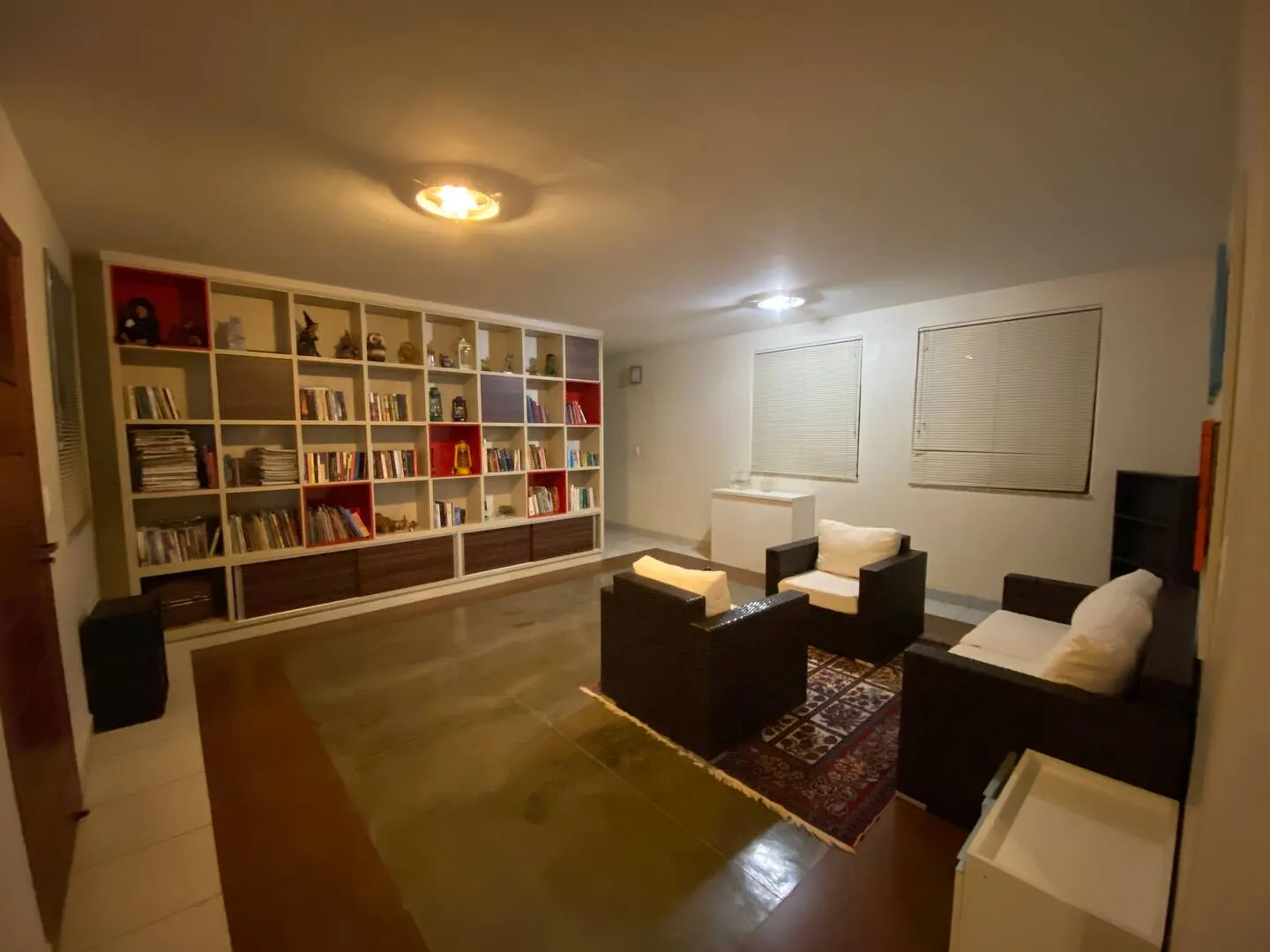 Biblioteca da casa, com estante e poltronas