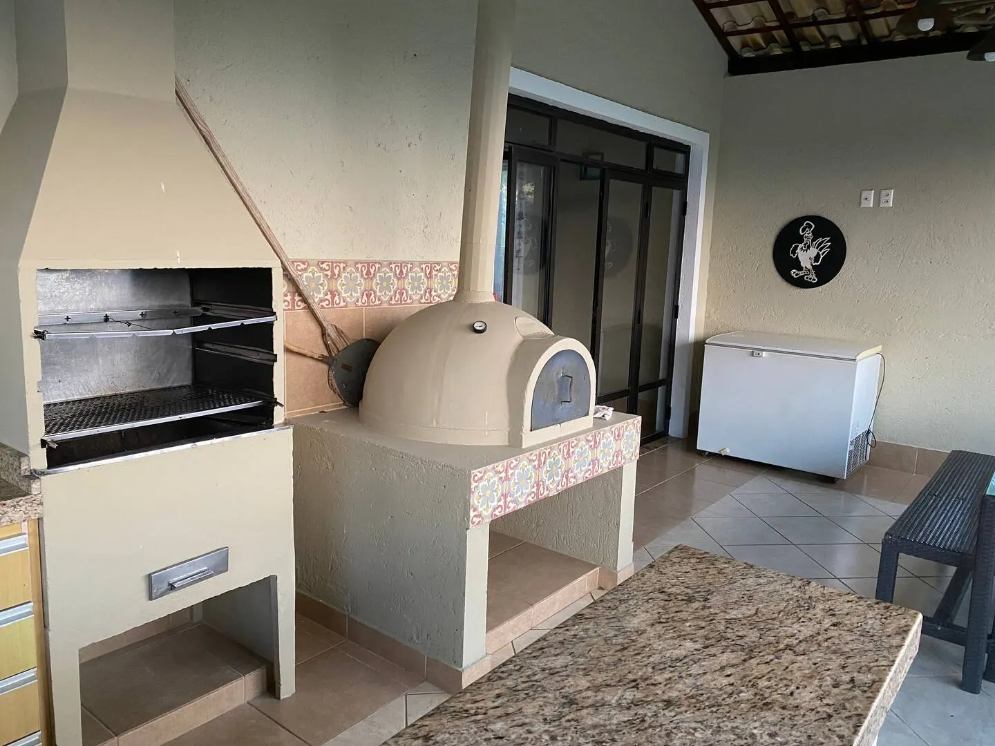 Área gourmet com churrasqueira e forno de pizza