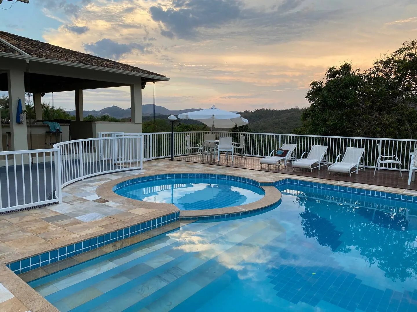 Piscina e deck da Chácara Cedro no fim da tarde