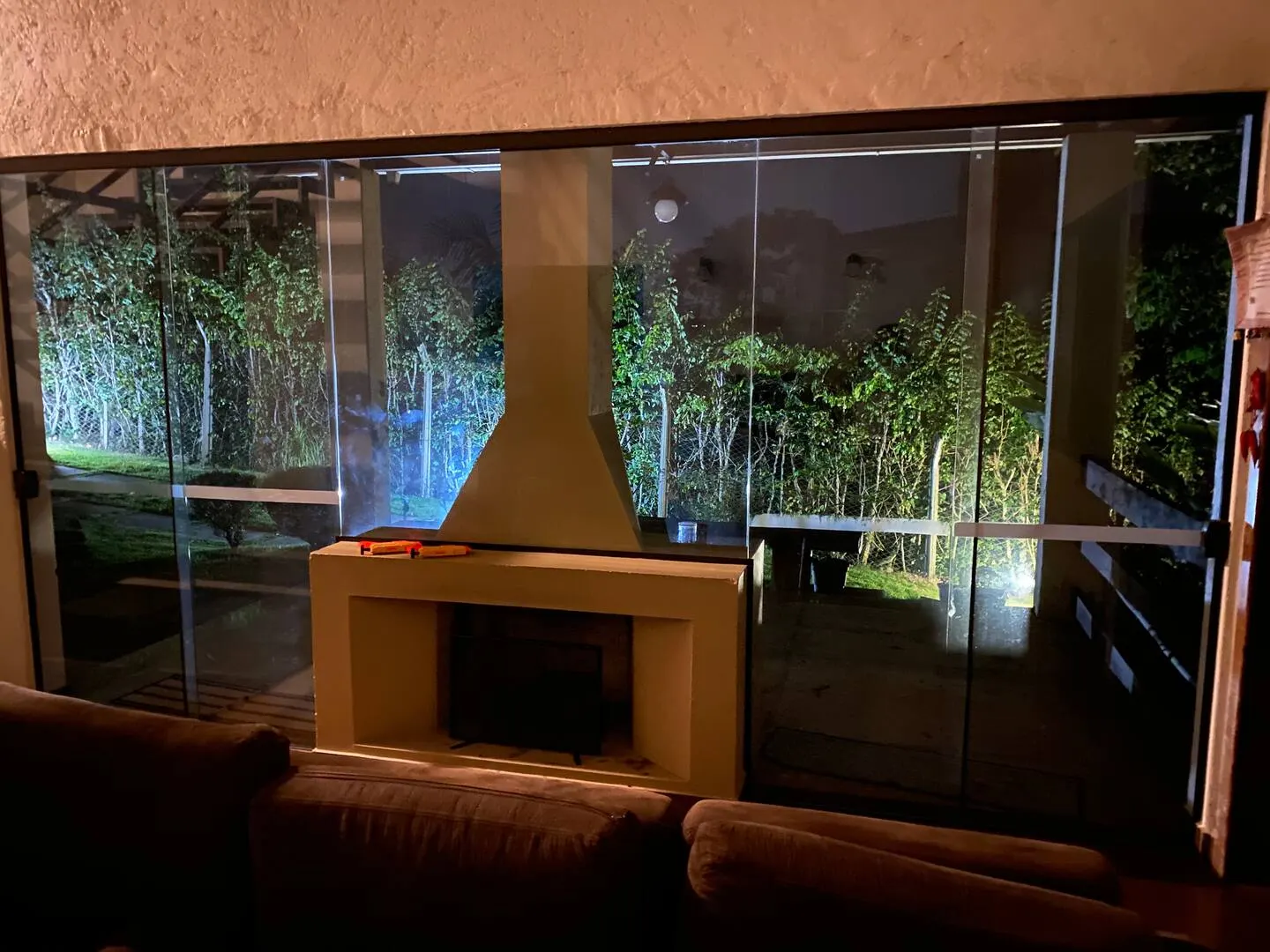 Sala de estar com lareira e janelas para o jardim
